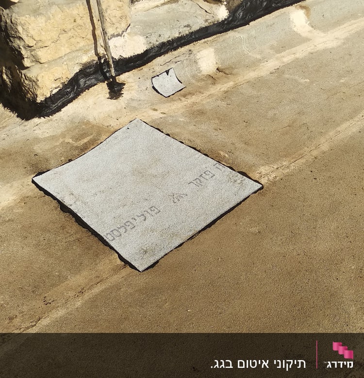 יריעה אטומה על גג ליד קיר אבן